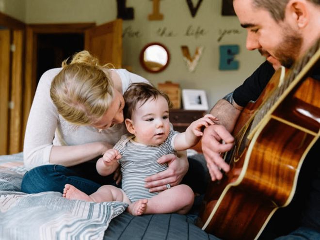 Mamá, bebé y papá tocando la guitarra. 5 beneficios de la música para el desarrollo infantil
