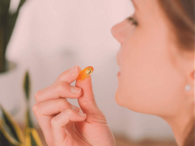 Side view of a woman taking a supplement
