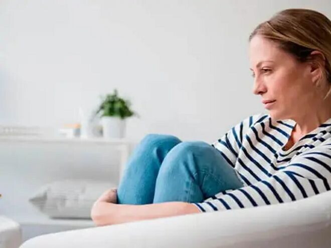 Imagen de una madre con mirada triste y gesto abatido, reflejando la decepción por un resultado negativo en la prueba de embarazo