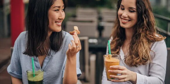 Dos mujeres tomando bebidas gaseosas.